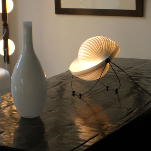 Lampe Eclipse luminaire design posée sur un meuble